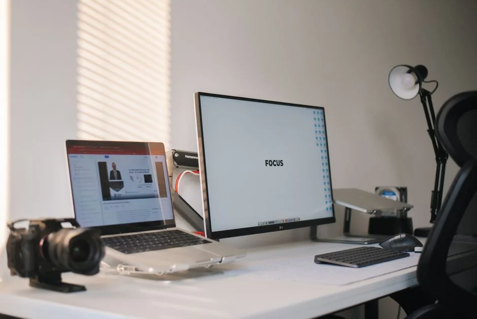 heros-img Gros plan sur un smartphone affichant une image floue, posé sur un bureau à côté d’un ordinateur portable.